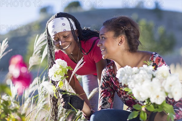 Mother and daughter picking flowers outdoors