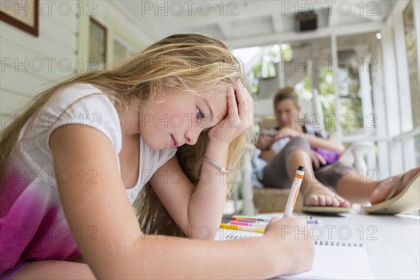 Caucasian mother and daughter relaxing on sun porch