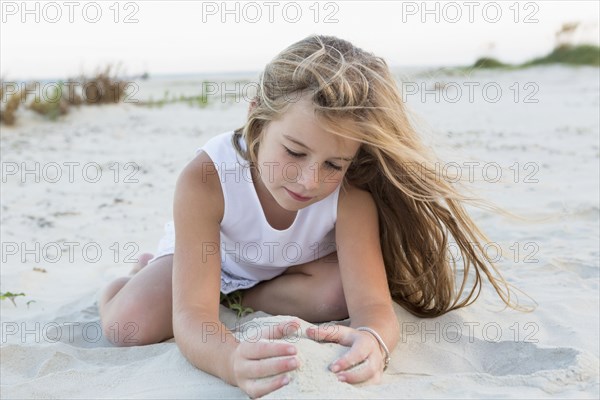 Girl playing in sand on beach