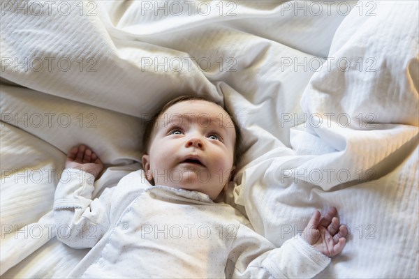 Caucasian baby boy laying in bed