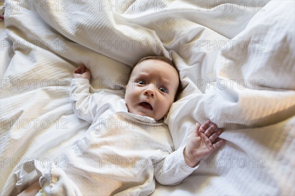 Caucasian baby gasping in bed