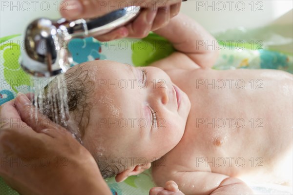 Caucasian mother giving baby boy a bath