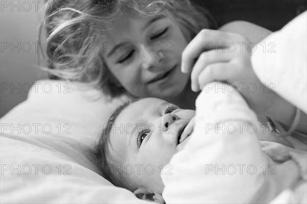 Caucasian girl playing with baby brother