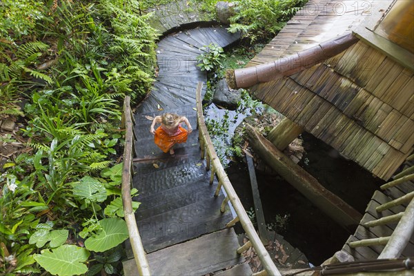 Caucasian girl running up steps in garden