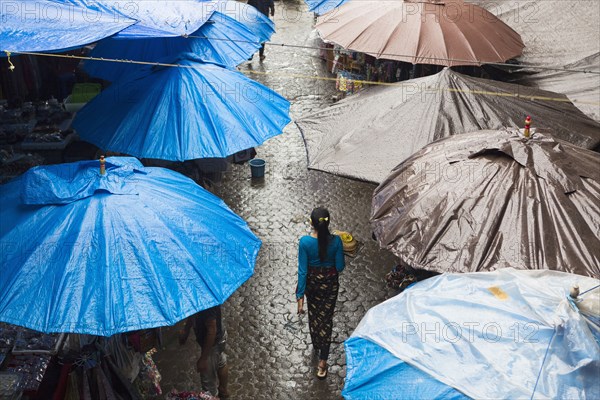 Rain falling over tarps and awnings of market stalls