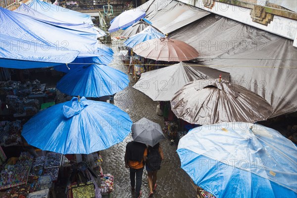 Rain falling over tarps and awnings of market stalls