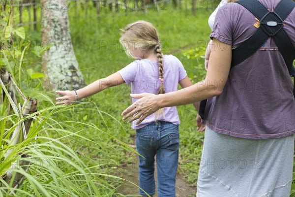 Caucasian mother and children walking in forest