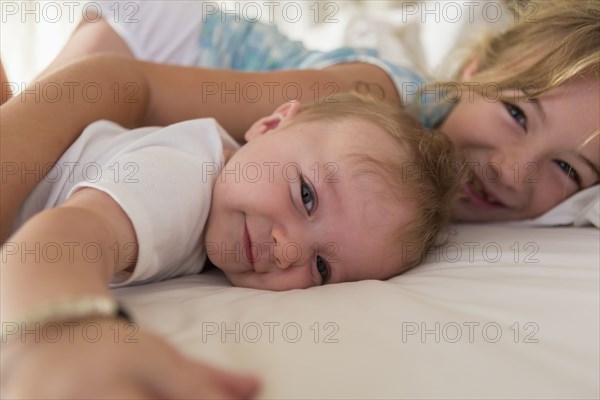 Caucasian siblings relaxing on sofa