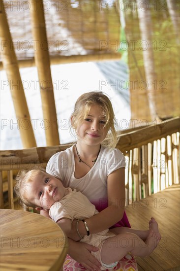 Caucasian girl holding baby sibling
