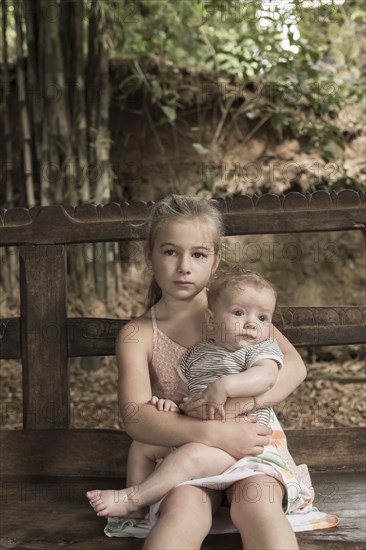 Caucasian girl holding baby boy outdoors