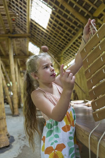 Caucasian girl playing with xylophone in workshop