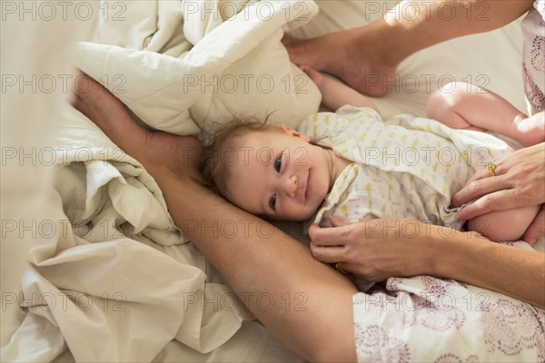 Caucasian mother and baby boy laying in bed