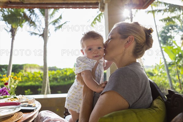 Caucasian mother kissing baby boy's cheek