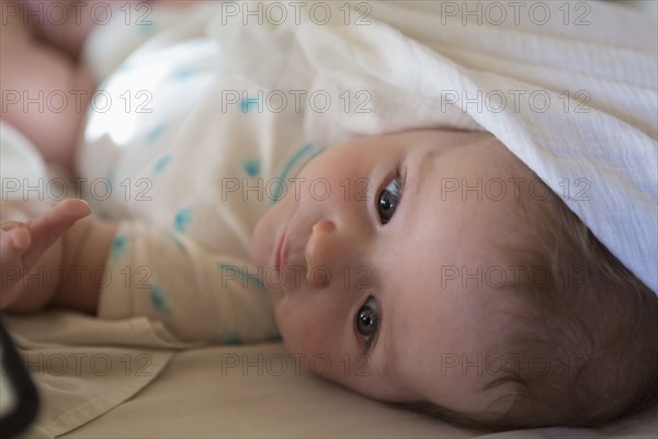 Caucasian baby boy laying on bed