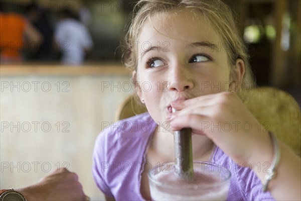 Caucasian girl drinking smoothie at breakfast