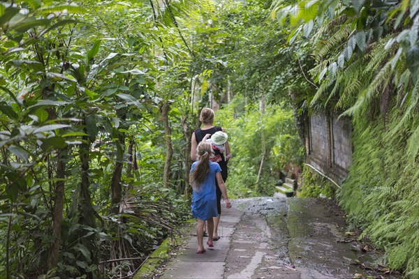 Caucasian family walking in tropical garden