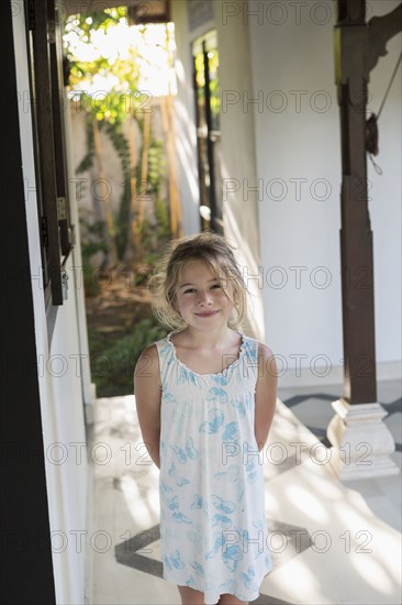 Caucasian girl smiling in foyer