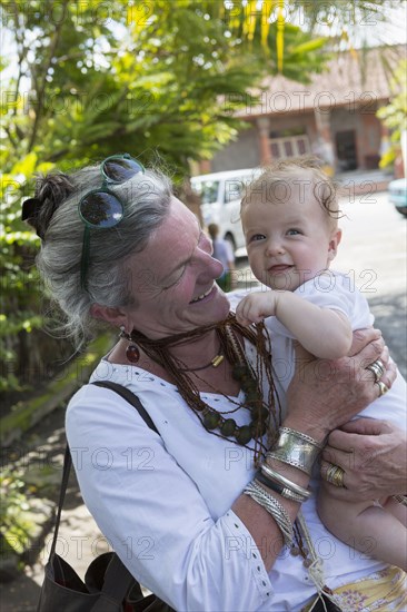 Caucasian grandmother holding happy baby boy