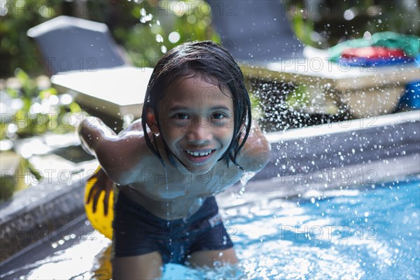 Balinese boy playing in swimming pool