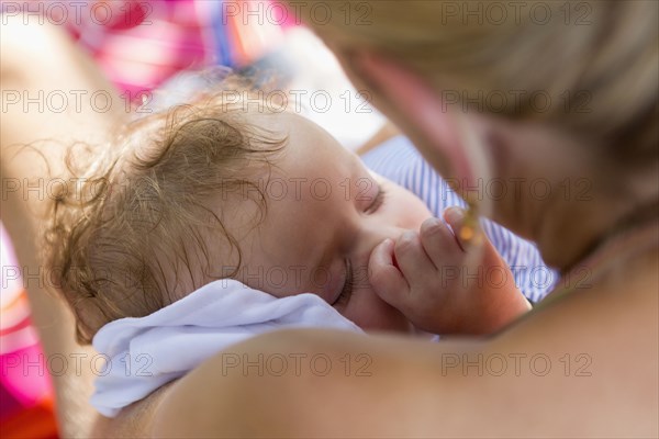 Caucasian mother cradling baby