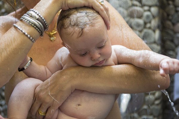 Caucasian mother and baby taking shower