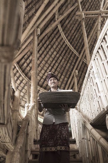 Balinese man carrying basket in hotel