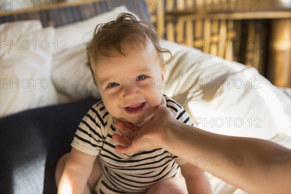 Caucasian baby laughing on bed