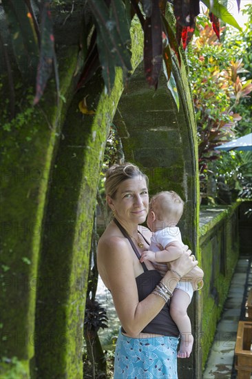 Caucasian mother holding baby boy in stone archway