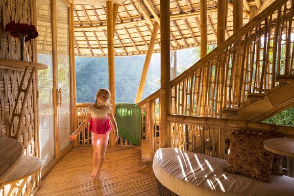 Caucasian girl walking in bamboo living room