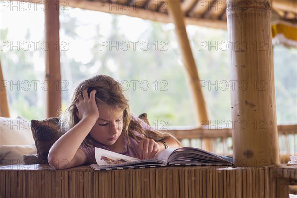 Caucasian girl reading book on patio