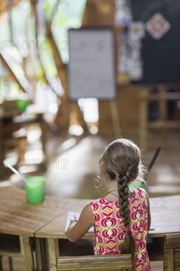 Caucasian girl painting at desk