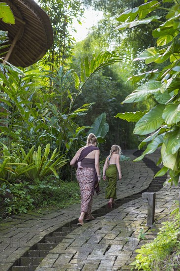 Mother and children walking along stone path