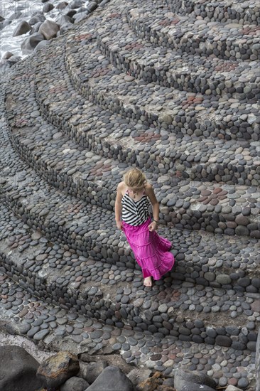 Caucasian girl climbing cobblestone steps