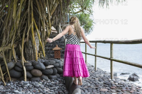 Caucasian girl walking along stone ledge