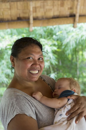 Smiling babysitter cradling baby