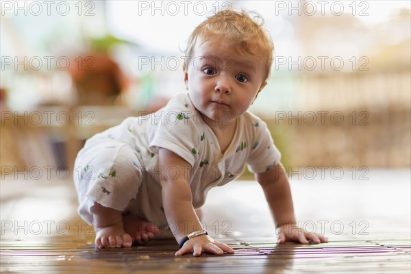 Caucasian baby crawling on floor