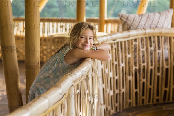 Caucasian girl leaning over railing