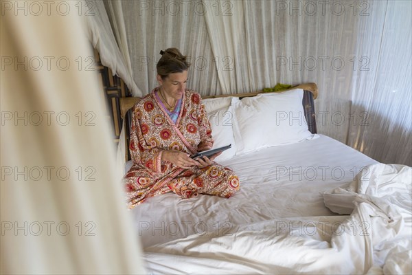 Caucasian woman using digital tablet in bed