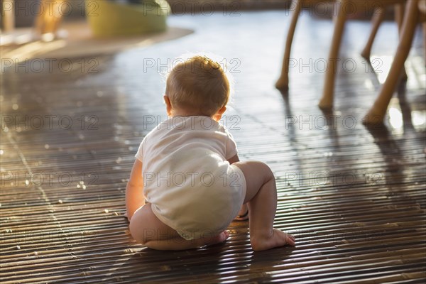 Caucasian baby crawling on floor