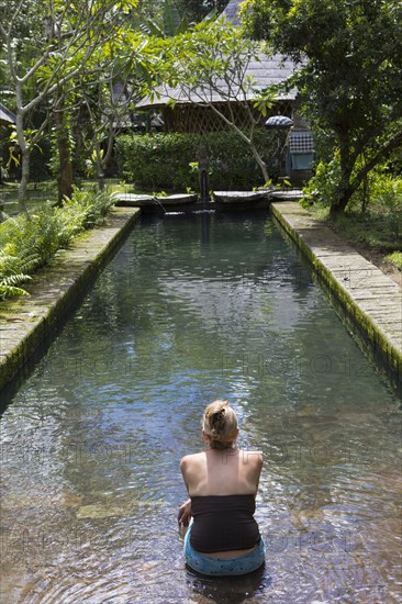 Caucasian woman sitting in modern pool