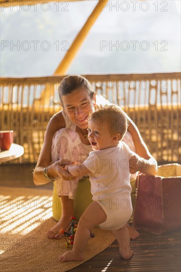 Caucasian mother and baby playing on floor