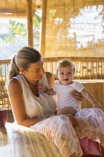 Caucasian mother and baby relaxing in living room