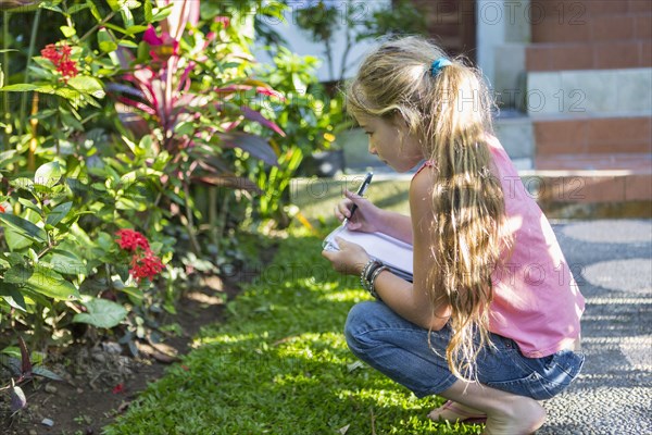 Caucasian girl examining tropical plants