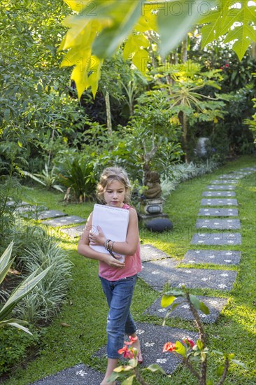 Caucasian girl with notebook in backyard