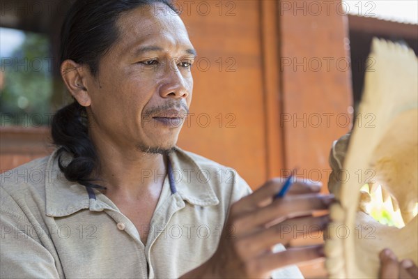 Wood worker examining piece in studio