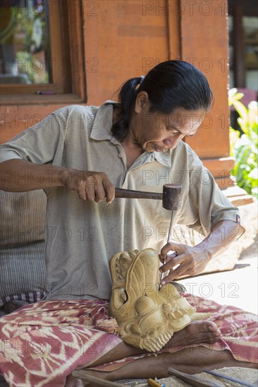 Wood worker chiseling piece in studio