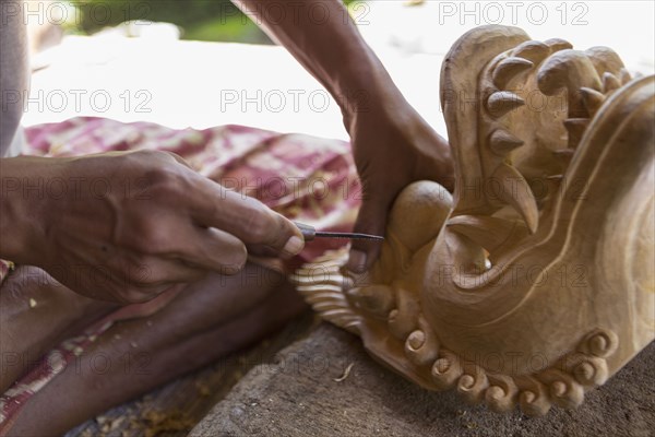 Wood worker chiseling piece in studio