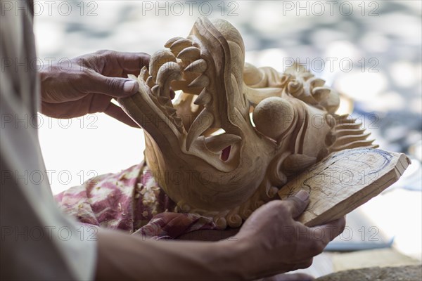 Wood worker examining piece in studio