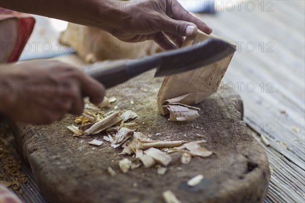 Wood worker chiseling piece in studio