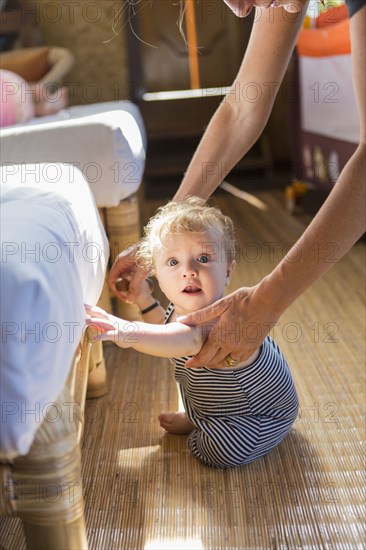 Caucasian baby sitting by sofa